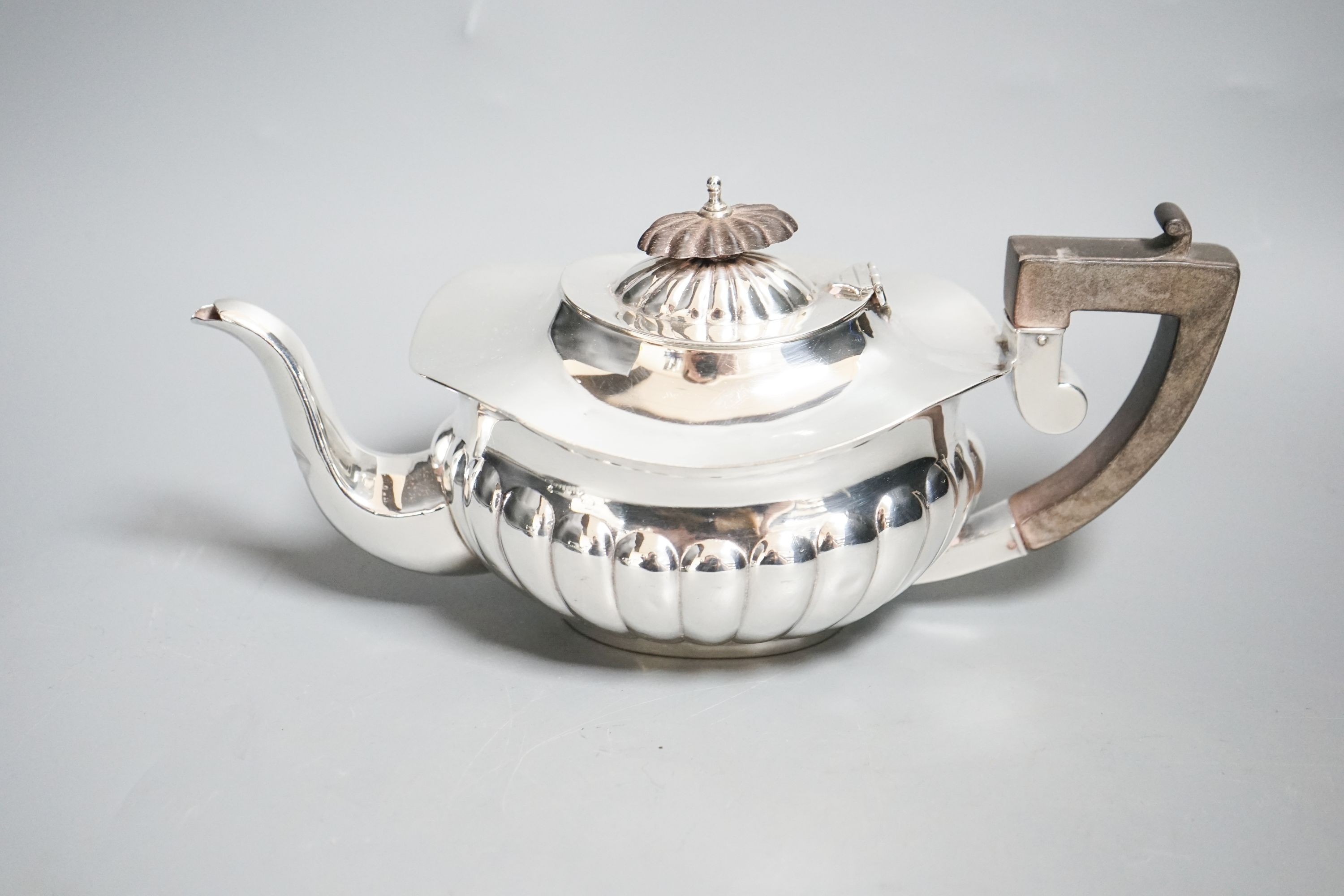 An Edwardian demi-fluted silver three piece bachelor's tea set, Chester, 1909, gross 15.5 oz.